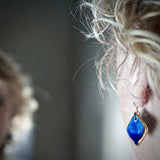 Boucles d'oreilles pour femme avec le pendentif bleu et or en forme de losange pour des noces de porcelaine